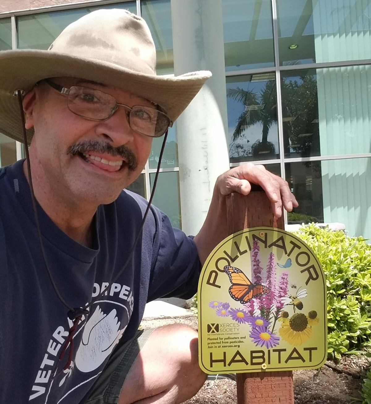 Augustin posing with Xerces pollinator habitat sign
