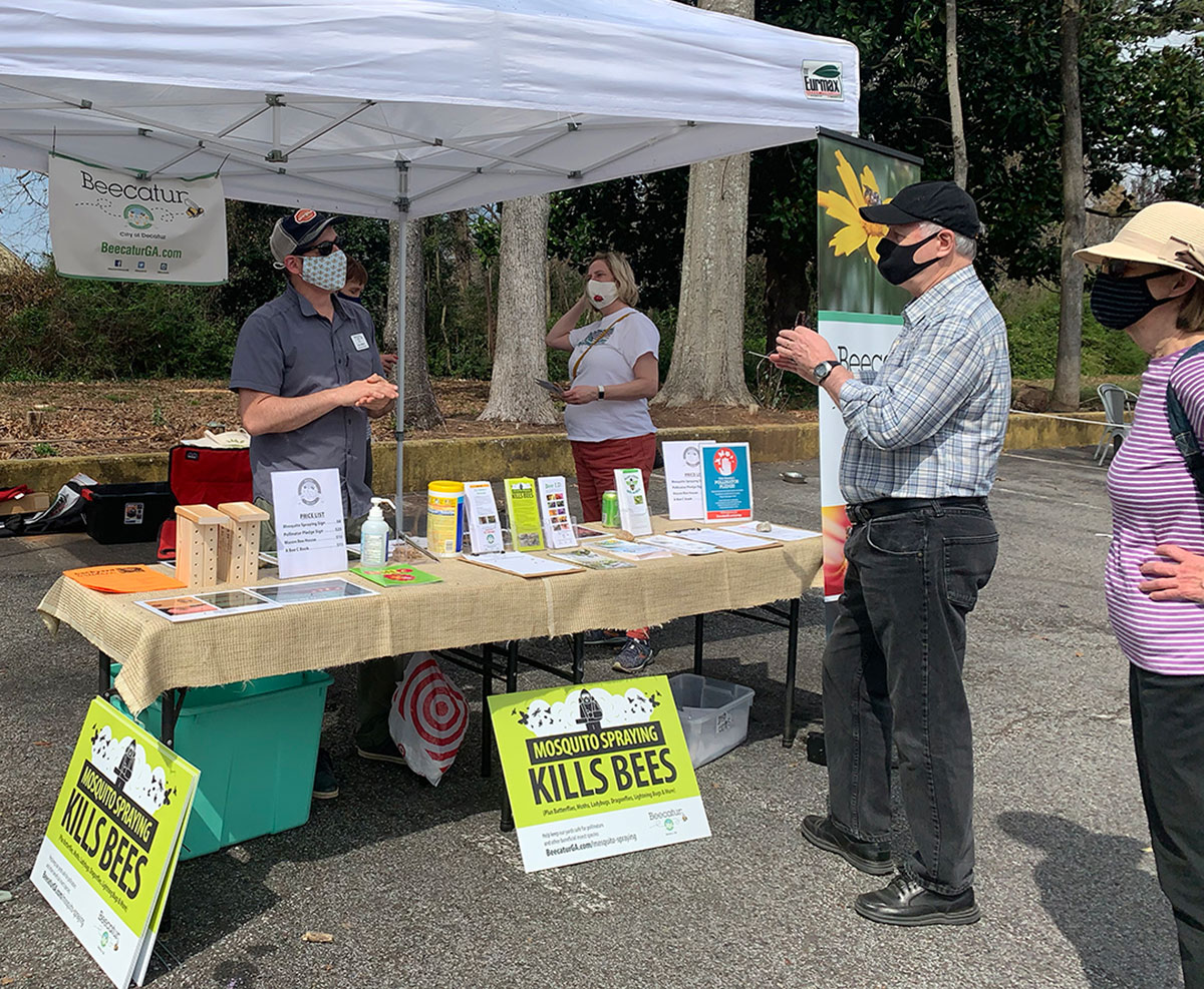 Volunteers with tent and materials about pollinators and not spraying for mosquitoes