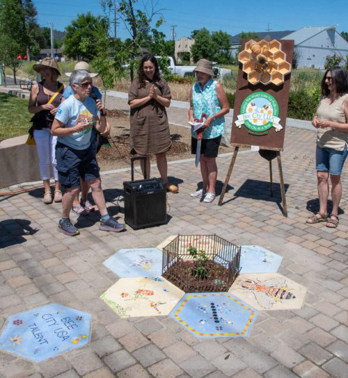 Talent Bee City committee standing around the small garden and tiles