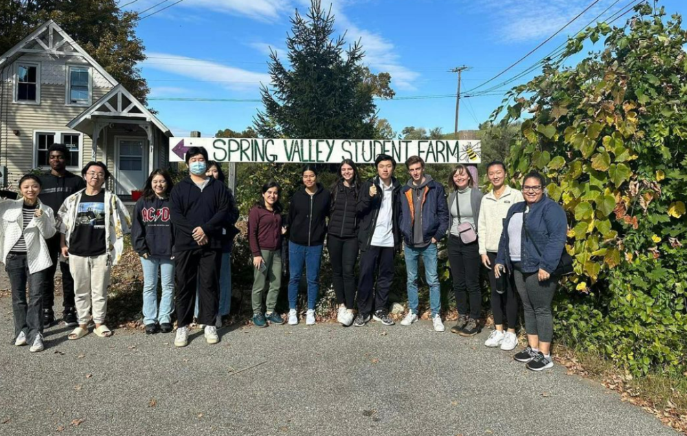 Student farmers in front of their "spring valley student farm" sign 