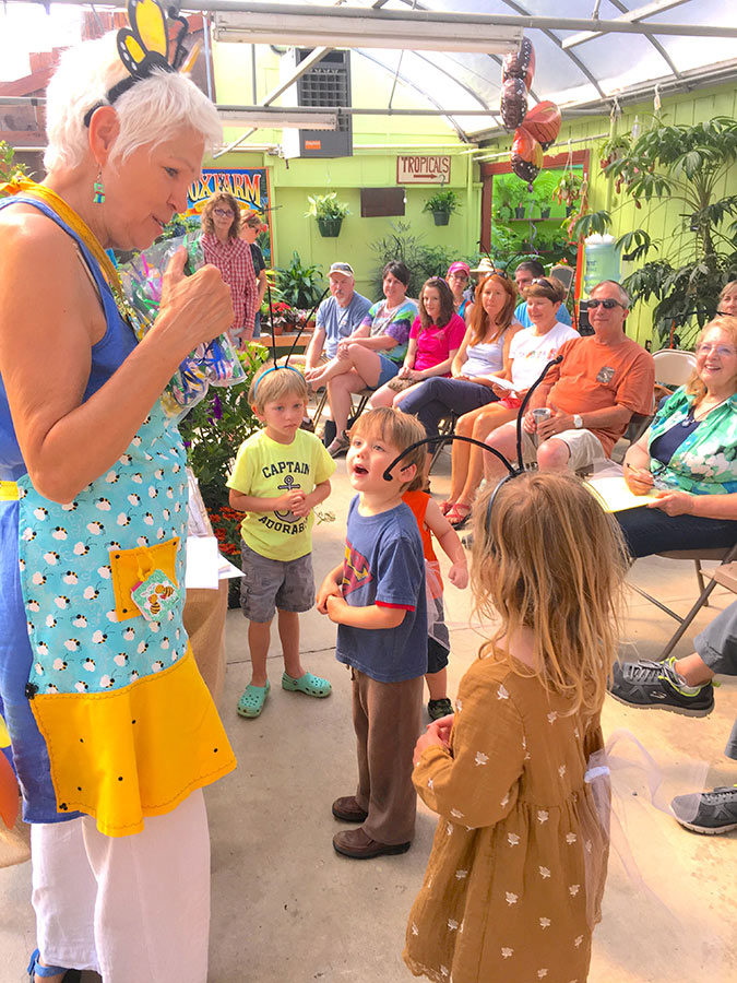 Phyllis Stiles, an older white woman with grey hair, talking to a crowd of young children and their parents at an event.