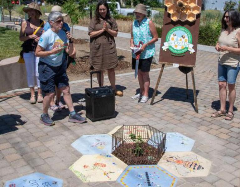 Bee City folks celebrating a tiny pollinator park 
