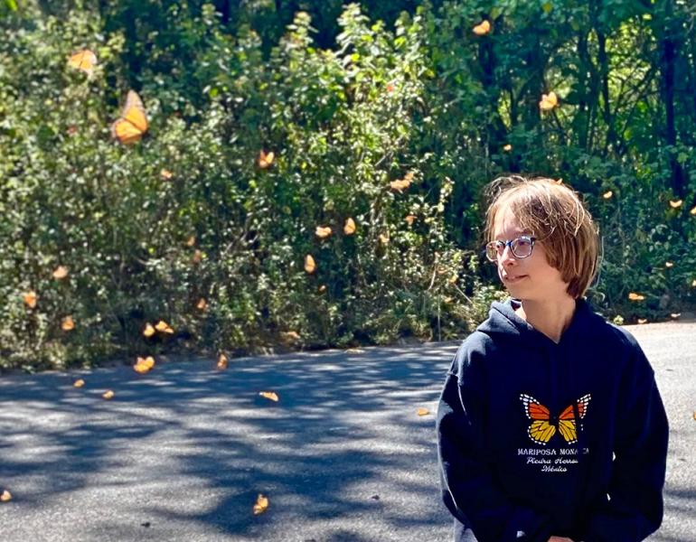 Noah Raven surrounded by flying monarch butterflies