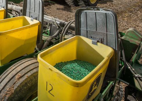 Pesticide-coated seeds in farming equipment