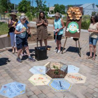 Bee City folks celebrating a tiny pollinator park 