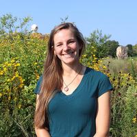 Julia Brokaw in front of a patch of sunflowers