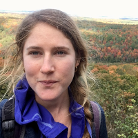 Avery Young standing above a forest of trees