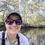 Photo of staff member Emilie Blevins kayaking on a stream in the Pacific Northwest